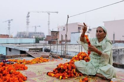 Shakila Bano hace una guirnalda de flores de caléndula en su casa: la economía del templo de Ayodhya depende en parte de los musulmanes.