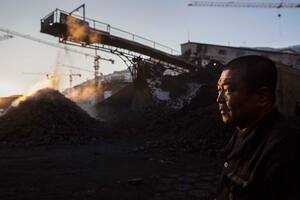SHANXI, CHINA -NOVEMBER 25: (CHINA, HONG KONG, MACAU, TAIWAN OUT) A Chinese mine worker looks on as coal is moved on a conveyor belt in a sorting area at a coal mine on November 25, 2015 in Shanxi, China. A history of heavy dependence on burning coal for energy has made China the source of nearly a third of the world's total carbon dioxide (CO2) emissions, the toxic pollutants widely cited by scientists and environmentalists as the primary cause of global warming. China's government has publicly set 2030 as a deadline to reach the country's emissions peak, and data suggest the country's coal consumption is already in decline. (Photo by Kevin Frayer/Getty Images)