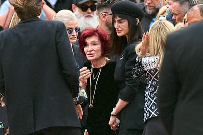 Sharon Osbourne junto a sus hijas Kelly (izquierda) y Aimee (derecha), en la procesión funeraria en Birmingham tras la muerte del cantante