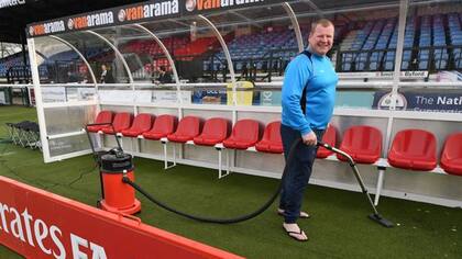 Shaw, limpiando los bancos de suplentes antes del partido