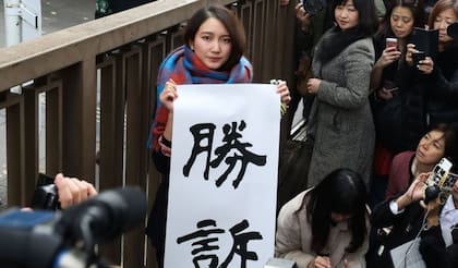 Shiori Ito ganó su histórico caso de violación en 2019. Sostiene un aviso que dice "victoria"