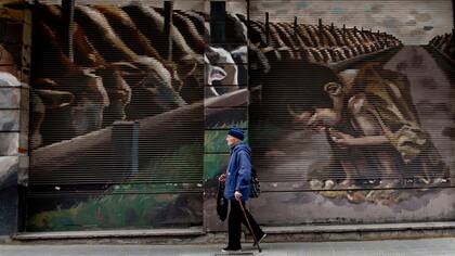 Mural de El Marian, titulado "Los juegos del hambre" en el que se ve un niño desnutrido junto a vacas que se alimentan de granos