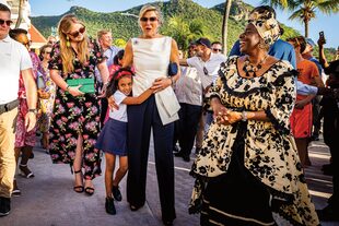 Siempre cercana, Máxima se deja abrazar por una niña, ante la mirada encantada de Amalia, que complementó su vestido con unos aros dorados de su mamá.