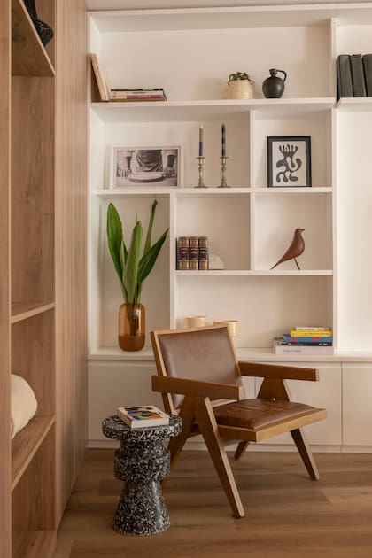 Silla negra y sillón estilo Jeanneret en madera (Landmark). Banquito ‘Ronda’ (Par en Par).