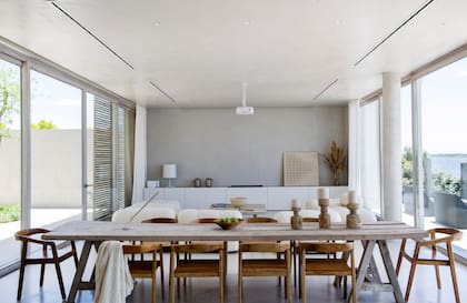 Sillas ‘Bali’ (Warehouse). Tanto la mesa baja como la del comedor fueron hechas por Celeste con tablones de los andamios usados en la obra. Sobre la consola (The Concrete Studio), obra (Cording Home).