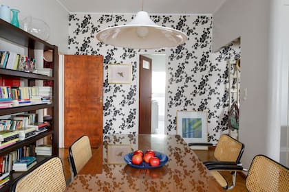 Sillas 'Cesca' con estructura tubular cromada y asiento y respaldo de ratán natural. Sobre la mesa de comedor con tapa de vidrio, una fuente comprada en el Centro Pompidou. En la pared, obra de Lupe Marin.