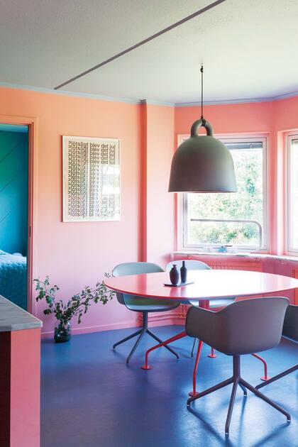 Sillas de madera y asiento de fibra de plástico (Muuto). La proximidad con el dormitorio da una idea de las dimensiones del departamento de dos dormitorios.