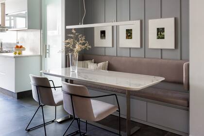 Sillas (Federico Churba) retapizadas con tejido Aquaclean gris, el mismo material y tono elegido para los almohadones del banco. Obras de Mariana Laplume.