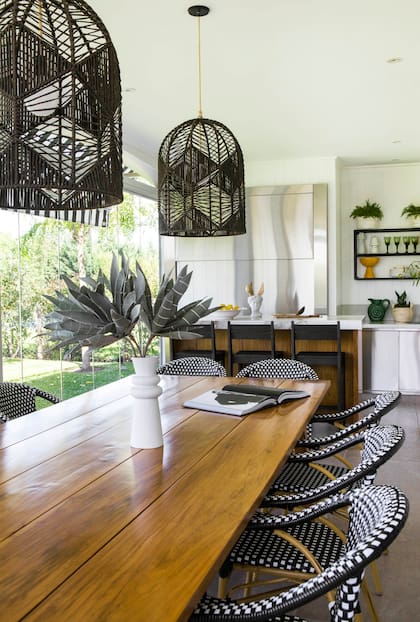 Sillas ‘París’ y lámparas de hilo natural
(Agustina Cerato). Paredews con listones de pintados de blanco. La barra combina tapa de Neolith con frente de madera. Parrilla con frente de acero inoxidable.