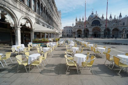 Sillas y mesas vacías se alinean afuera de un restaurante en la Plaza de San Marcos en Venecia, Italia; el coronavirus castigará a los comerciantes y la mafia estará lista para sacar provecho