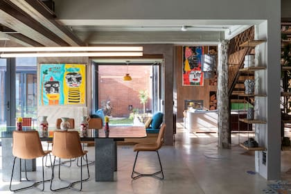 Sillas (Zamibia Deco). Sobre la mesa que ya tenían, pero que aquí encontró un entorno ideal, vasijas (Casaideas). Piso de hormigón alisado (Edfan). Carpinterías de PVC color gris grafito con DVH (Aberturas Australes). Tubos ‘Puma Led’ (Club Led). Cuadro de Fede Runner.