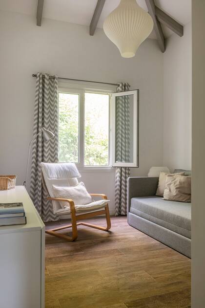 Sillón cama diseñado a medida (MTD Arquitectura), silla mecedora (Ikea), cortinas (La Deco Privé), lámpara de techo (E27 Iluminación).