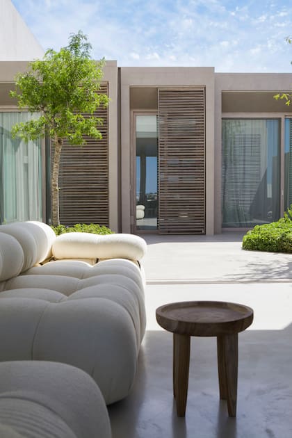 Sillón ‘Camaleonda’ junto a una mesa de apoyo hecha con madera recuperada (Estudio Trae).