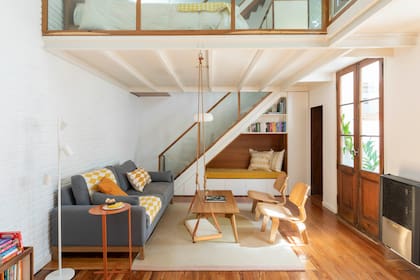Sillón con almohadones y manta (Mercedes Segura). Alfombra (Elementos Argentinos). Mesa de centro (Boulevard Furniture). Lámpara de pie (Dimm). La dueña de casa compró la hamaca (que sujetaron del forjado metálico) especialmente para este espacio.