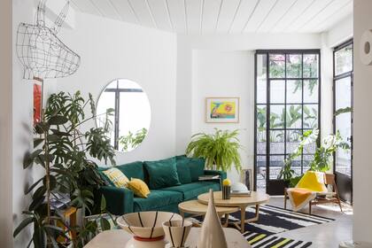 Sillón cubo tapizado en pana verde inglés, almohadones estampados a mano (Mercedes Segura), mesas bajas ‘Nido’ (Harturo).