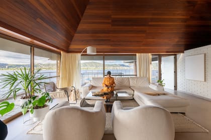 Sillón en L de tres cuerpos y sillones individuales (Siuk Studio), alfombra (Awanay), lámpara de pie (Huup). Las paredes de ladrillos a la vista fueron pintadas con 'Cherish in the Word 0029' (Sinteplast).