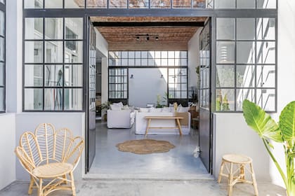 Sillón ‘Flor’ y banqueta de mimbre (ambos de Brugués Mosconi). Alfombras de fibras naturales circular (Apatheia)