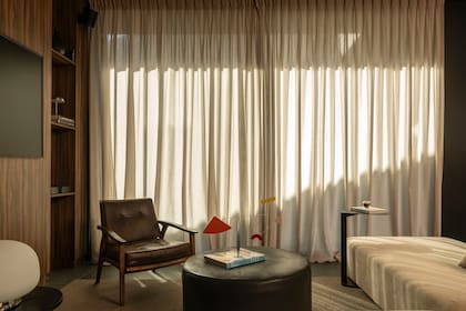 Sillón (Helmut), mesa de arriba y puff central –que ya tenían los dueños–, butaca (a pedido, Indecor Thonet), alfombra (El Espartano).