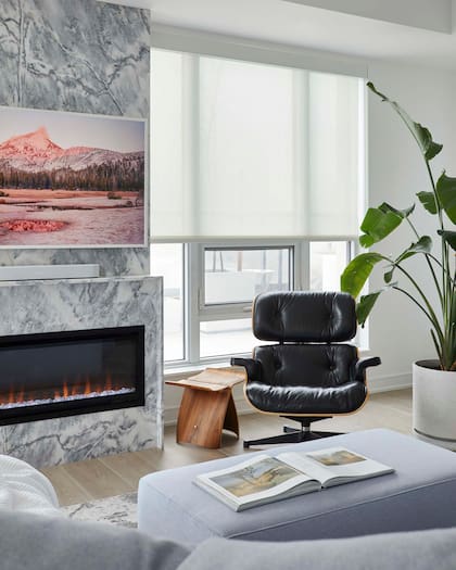 Sillón 'Lounge Chair & Ottoman' (Eames) en combinación con una pequeña mesa de arrime de madera.