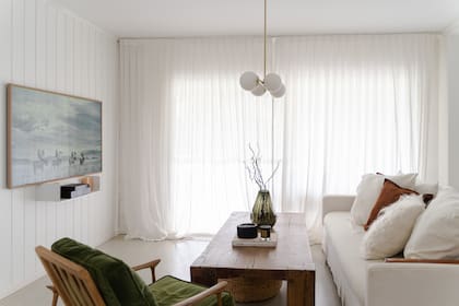 Sillón Mid Century (Esto Es Regio), mesa de centro (Gloria Atelier Deco), vaso de vidrio (Édition Tupé). Colgante (DIMM). Revestimiento de machimbre pintado. Televisor 'The Frame' (Samsung)