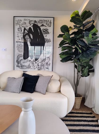 Sillón, objetos deco y planta artifical (Estudio GOD). Cuadro de Adriana Carambia (Diderot.art).