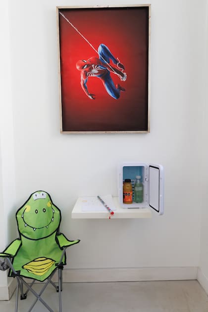 Sillón, poster de Spider Man y una heladerita para tener bebidas frías mientras Fermín está en su cuarto, jugando
