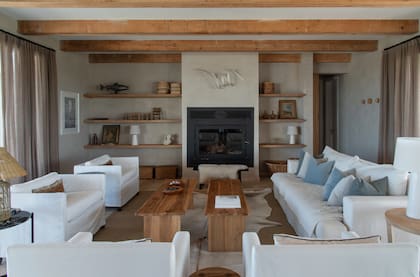 Sillón tres cuerpos (Les Decorateurs) y sillones cuadrados (Eugenio Aguirre). Bancos de madera (Sin Almidón). Pieza metálica plegada de Natalia Abot y una trucha en chapa por Duncan Grant (en honor al dueño de casa, apasionado pescador).