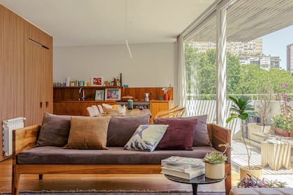 Sillón y almohadones hechos a medida con proveedores del estudio (Malva Arquitectura). Plantas (Tou Tou Galpón). Al fondo, el revestimiento varillado ‘Novel Wall ’ (The Flooring Company) deja oculta la heladera.