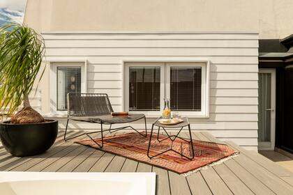 Sillon y apoya pies con estructura de hierro y tejido de soga para resistir a la intemperie (diseño del estudio). Cuando salen al solarium, sacan también la alfombra, que ya tenían.