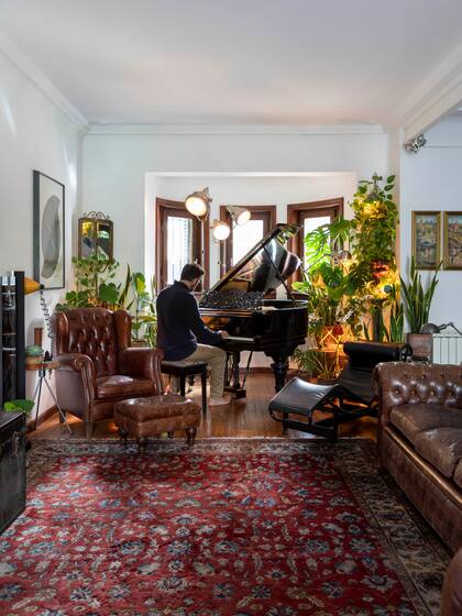 Sillones ‘Chesterfield’ de cuero marrón y alfombra persa. Y el Steinway, por supuesto