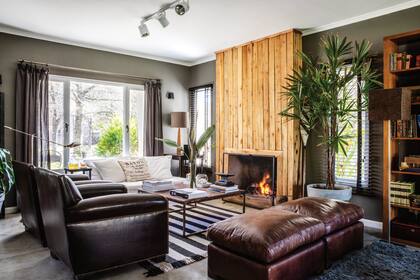 Sillones de cuero (Paul French Gallery) y butacones heredados y retapizados en cuero. Cortinas (Andrea Solari). Revestimiento de chimenea (Arq. Patricio Jones). Para las paredes, Iván eligió el tono ‘K155’ de Quimtex (Química Llana).