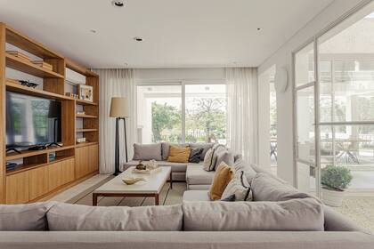 Sillones a medida tapizados en lino con doble funda, almohadones, mesa laqueada con tapa entelada en gasa, biblioteca de petirib, cortinas de lino (todo de Muliere-Padilla). Alfombra (Rugit).