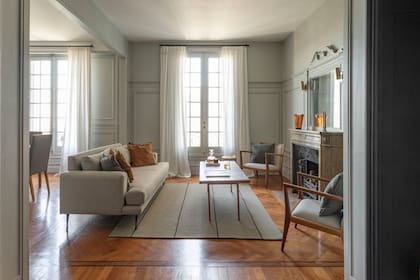 Sillones y almohadones (Nativa Muebles). Alfombra (Rugit). Sobre la chimenea, florero de cristal ámbar (Deco Vintage New).