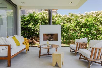 Sillones y mesa baja de lapacho (Arq. Maura Ambrosetto) junto al hogar exterior. Por si en algún momento deciden cerrar parte de la galería, la equiparon con losa radiante, lista para conectar y usar.