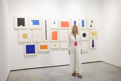 Silvia Arrozés con obra de Azul Caverna en el stand de la galería uruguaya Del Paseo