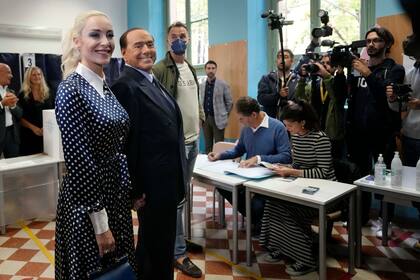 Silvio Berlusconi, líder de Forza Italia, flanqueado por su pareja, Marta Fascina, tras depositar su voto en un colegio electoral en Milán, Italia, el 25 de septiembre de 2022, en Milán, Italia