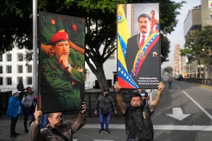 Simpatizantes chavistas levantan carteles de Chávez y Maduro este sábado en Caracas.