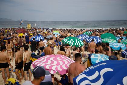 Simpatizantes de Boca comienzan a desplegar banderas en la playa de Copacabana
