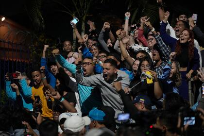 Simpatizantes de la aspirante opositora María Corina Machado, en el centro, festejan después de escuchar los resultados que le daban como ganadora de las primarias de la oposición, en su sede de campaña en Caracas, Venezuela, el domingo 22 de octubre de 22, 2023.