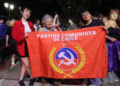 Simpatizantes de la candidata presidencial chilena Jeannette Jara, de la coalición Unidad por Chile, muestran una bandera durante un discurso tras la publicación de los primeros resultados de las encuestas a pie de urna de las elecciones generales en Santiago el 16 de noviembre de 2025