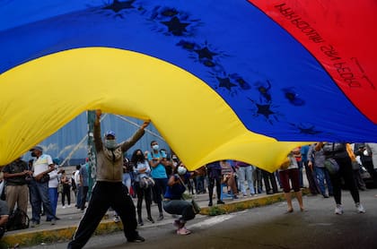 Simpatizantes de Tomás Guanipa, candidato a la alcaldía de la Mesa de la Unidad Democrática (MUD) del municipio Libertador, ondean una bandera venezolana durante un mitin 