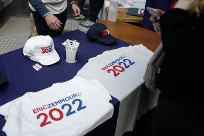 Simpatizantes del candidato de extrema derecha a la presidencia Eric Zemmour venden camisetas y gorras previo al primer mitin de campaña del candidato, el domingo 5 de 2021, en Villepinte, al norte de París.