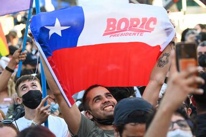 Simpatizantes del candidato presidencial chileno Gabriel Boric, del partido Apruebo Dignidad, celebran tras los primeros resultados oficiales de la segunda vuelta de las elecciones presidenciales, en Santiago, el 19 de diciembre de 2021.
