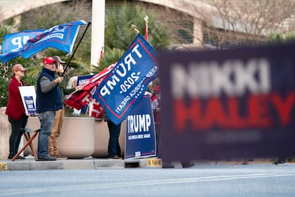 Simpatizantes del expresidente Donald Trump, precandidato republicano a la presidencia, sostienen letreros afuera de un evento de campaña de Nikki Haley, también precandidata republicana a la presidencia, el miércoles 24 de enero de 2024, en North Charleston, Carolina del Sur