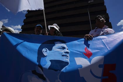 Simpatizantes del movimiento Revolución Ciudadana llevan una pancarta con una imagen del expresidente Rafael Correa (Archivo)