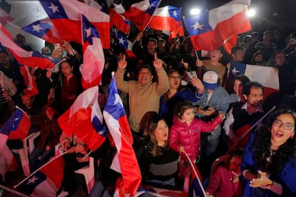 Simpatizantes del ultraderechista Partido Republicano celebran la victoria de sus candidatos durante las elecciones para elegir a los miembros de un Consejo Constitucional que redactará una nueva propuesta de Constitución, en la sede del Partido Republicano en Santiago, el 7 de mayo de 2023.