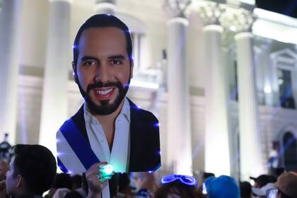Simpatizantes que sostienen una imagen del presidente Nayib Bukele se reúnen para celebrar los resultados de las elecciones generales en la plaza Gerardo Barrios, el domingo 4 de febrero de 2024, en el centro de San Salvador, El Salvador. (AP Foto/Salvador Meléndez)
