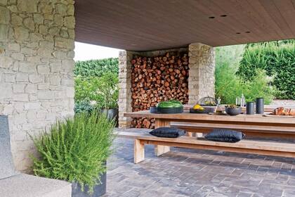 Simples. Mesa y bancos de madera maciza. Se proyectó un leñero rodeado de piedra, otra textura que volverá a aparecer en la suite.