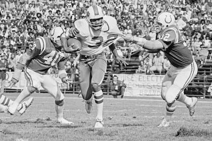 Simpson, de Buffalo Bills, avanzar tironeado por Mike Curtis, Baltimore Colts, el 12 de octubre de 1975; fue un notable corredor en fútbol americano y murió la semana pasada a los 76 años.