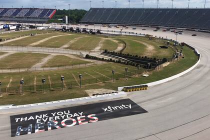 Sin público y ajustándose al protocolo: los autos recorren el óvalo del autódromo de Darlington, en Carolina del Sur; cada uno de los 40 pilotos estuvo acompañado por 15 asistentes en el equipo